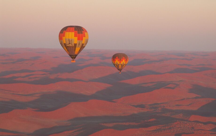 Zwei Heißluftballons bei Sonnenaufgang über der Namib Wüste